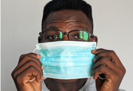 young black man putting on medical mask